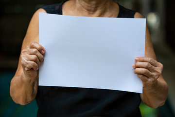 Senior woman's Hands holding paper blank a4 size in bokeh background, Selective focus, Communication, business concept