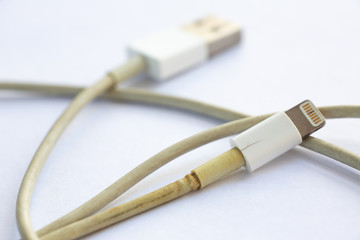Old Smart Phone Charger Cable broken on white acrylic table background, Close up & Macro shot, Selective focus, Technology, Business concept