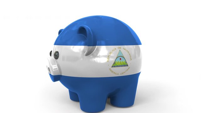 Coins fall into piggy bank painted with flag of Nicaragua. National banking system or savings related conceptual 3D animation