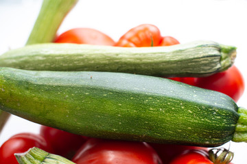 fresh vegetables in the foreground, zucchini tomatoes and cucumbers