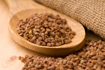 Buckwheat in a wooden spoon. On wood