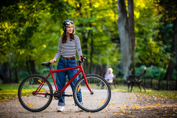 Woman standing with bike in city park