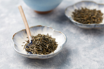 Dried Green Tea Leaves on Bright Background. Close up. 