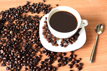 cup of coffee and beans on wooden background