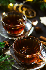 Couple cups of hot spicy tea with anise and cinnamon, selective focus