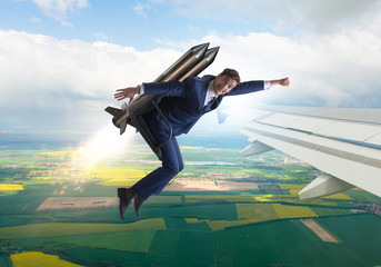 Businessman flying next to commercial flight