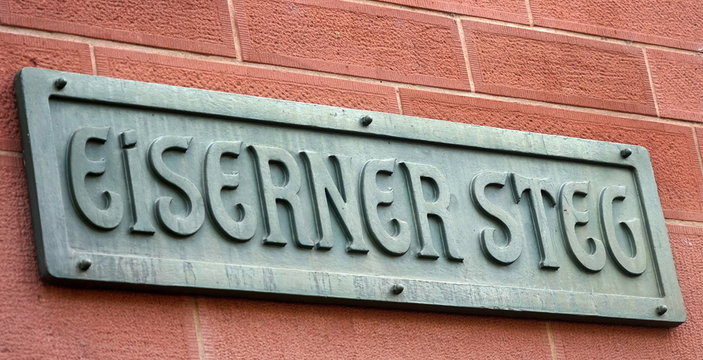 Schild "Eiserner Steg" an einer Backsteinmauer