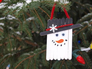 Simple handmade Christmas ornament on a snowy outdoor tree