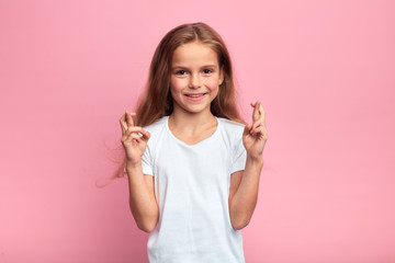 little beautiful cheerful girl crossing fingers with hope Luck and superstitious concept.close up...