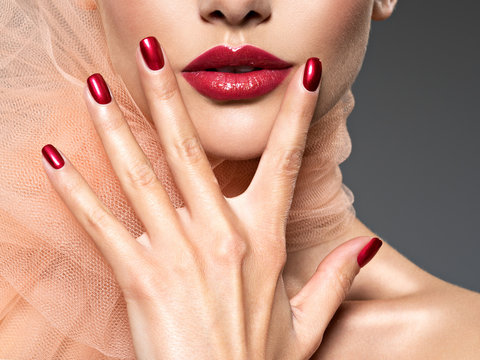 Closeup Face Of A  Woman With Red Nails And Lips