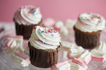 yummy cupcakess prepared for a party, event,isolated pink background, three cipcakes for sweet tooth