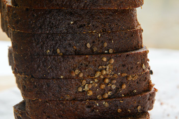 A loaf of black bread cut into pieces and sprinkled with coriander close-up. Concept - healthy natural food, diet