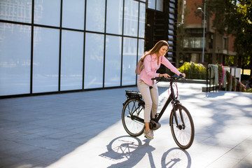 Fototapeta premium Young woman riding an electric bicycle