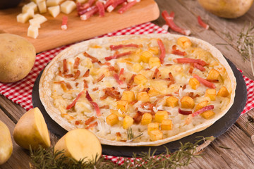 Tart with fried potato, raclette cheese and smoke flavour bacon.