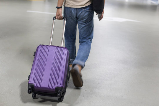 Man pulling suitcase and entering hotel