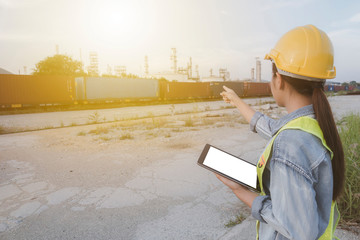 concept of industrial or Oil refinery or Pollution and environment. engineers female holding digital tablet working orders the oil and gas refinery plant or Examine the environment and air pollution. - Powered by Adobe