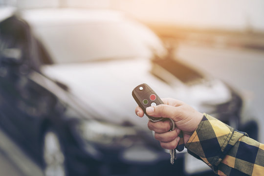 Close up hand of woman presses on the remote control car alarm systems or Car start stop system with finger pressing the button green or red, horizontal image.Technology, Car security system concept