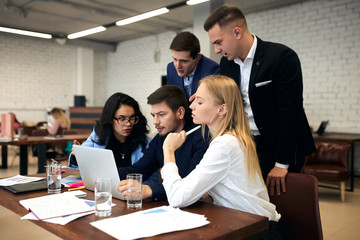 young people in elegant suits working with laptop in the mordern room, studends preparing for exam, making presentation. close up side view photo.