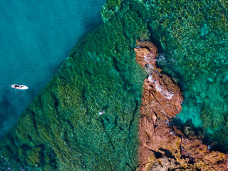 Aerial view of a paddle board in the water floating on a transparent sea, snorkeling. Bathers at sea. Tropea, Calabria, Italy. Diving relaxation and summer vacations. Italian coasts, beaches and rocks