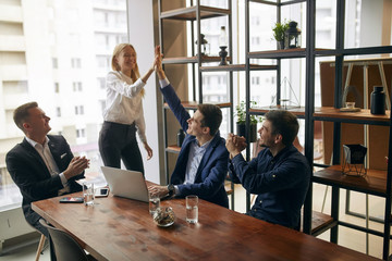 team of business people giving high five in the office at the meeting. good job, happiness,...