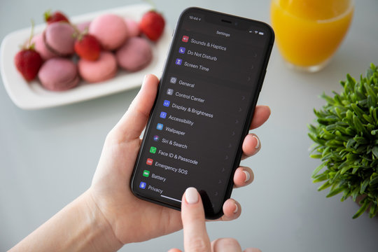 Woman hand holding iPhone 11 with home screen IOS 13