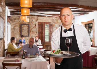 Waiter holding tray with dish