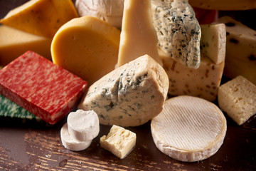 Various types of cheese on rustic wooden table,