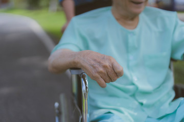 Family or Assistant, Retirement, patient or elderly caregiver, health care concept . Health visitor or son walking with disabled father in wheelchair at park or hospital during home visit in holiday