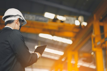 Engineer in safety helmet finger gesture scrolling in touchpad while searching for technical data at Industry Manufacturing Factory. Maintenance engineer using digital tablet control, inspect Project