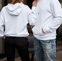 young couple wearing hoodie. man has white hoodie. girl has white hoodie