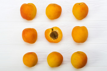 Apricots. Ripe fresh apricots on a wooden white background, top view.