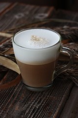 Delicious cappuccino with milk on a wooden table