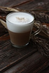 Delicious cappuccino with milk on a wooden table