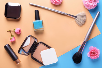Obraz na płótnie Canvas Flat view of cosmetics - lipstic, face-powder, brushes, nail polish
