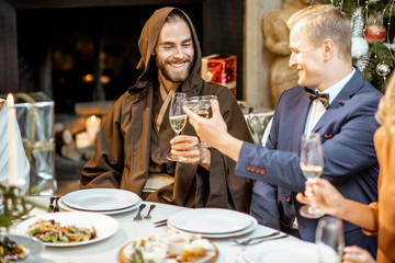Elegantly dressed people having a festive dinner indoors