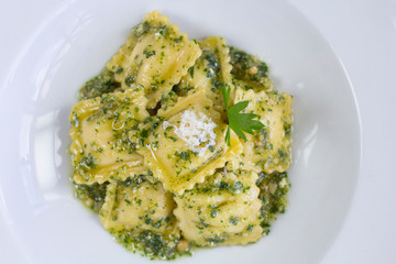 Italian ravioli stuffed with ricotta cheese and pistachio pesto, top view.