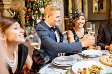 Elegantly dressed people having a festive dinner indoors