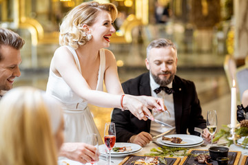 Elegant people having festive dinner at the restaurant