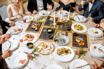 Elegantly dressed people having a festive dinner indoors