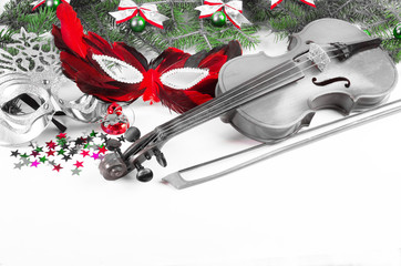 Violin, carnival masks, branches of spruce and New Year decorations.