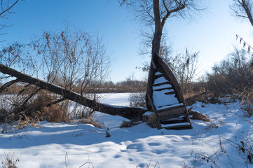 An old wooden boat is bombarded with snow. The end of the fish season.