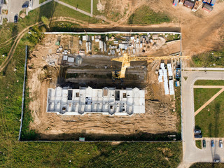 Aerial view drone photo of construction site. Tower cranes and industrial machinery for building construction.