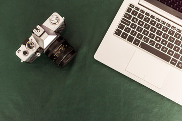 Camara retro , teclado de notebook y cuaderno sobre mantel verde