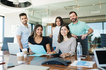Smiling Colleagues Planning In Meeting Room