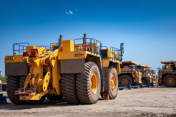 Heavy yellow quarry tractor at repair station at sunny cloudless day