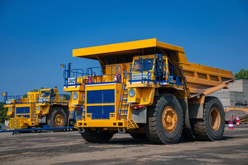 Fototapeta na wymiar heavy yellow quarry dump truck at repair station at sunny cloudless day