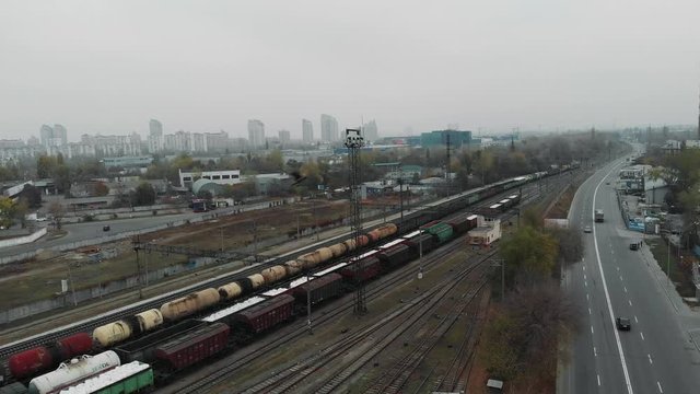 Freight train with cargo moving through the city railway station