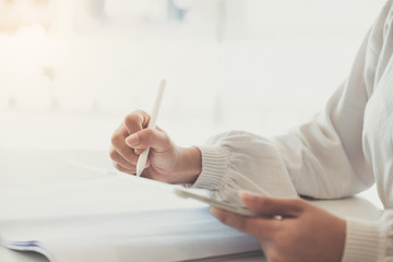 Close up of Woman holding new version digital tablet device in hands with smart pencil.