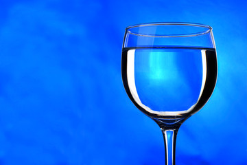 translucent drink in glass with blue background