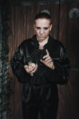 halloween make up. scary man ready for party. vampire guy with black eyes and tears in a black silk shirt with a frill.